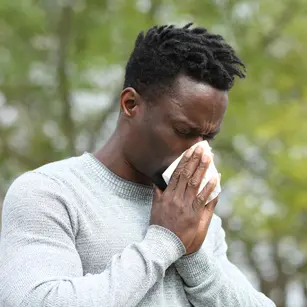 man blowing his nose