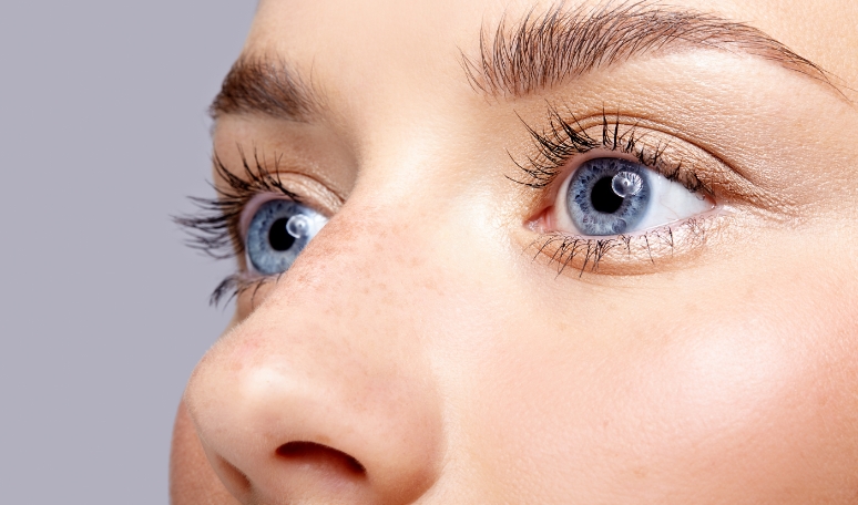 close up of a face with blue eyes and freckles