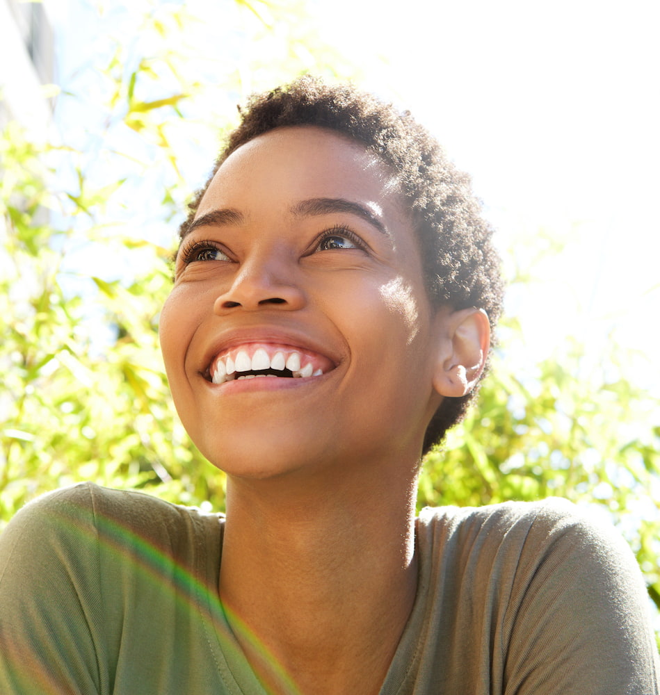 woman smiling outdoors on a sunny day