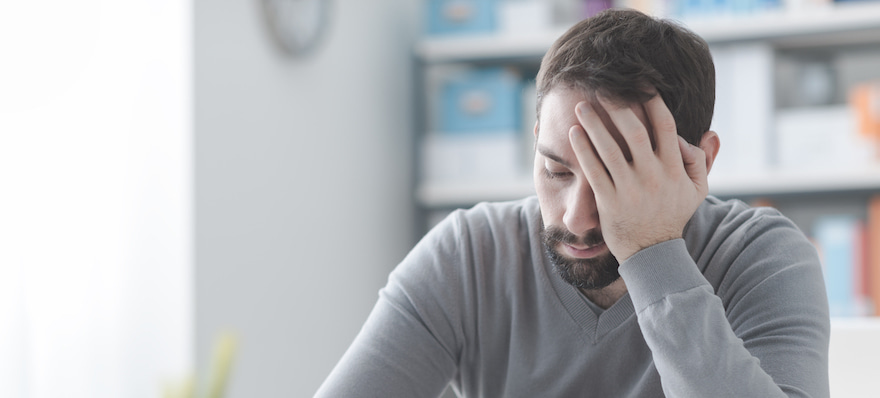 man holding his head in pain