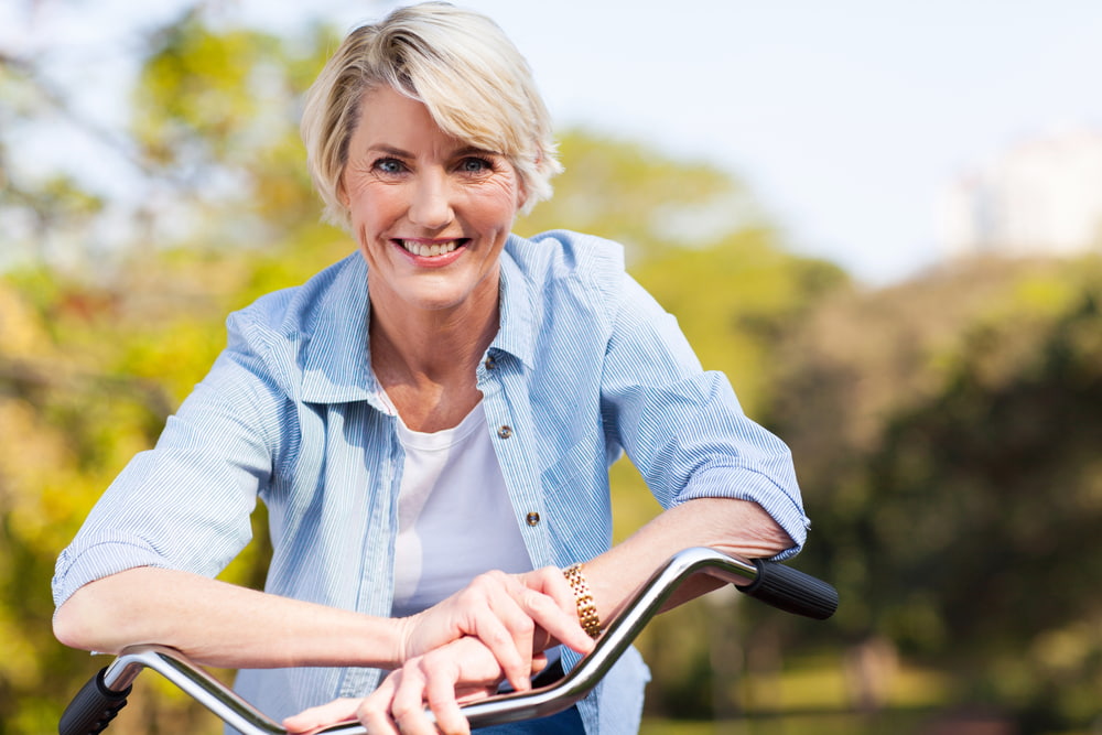 senior woman smiling while riding a bike