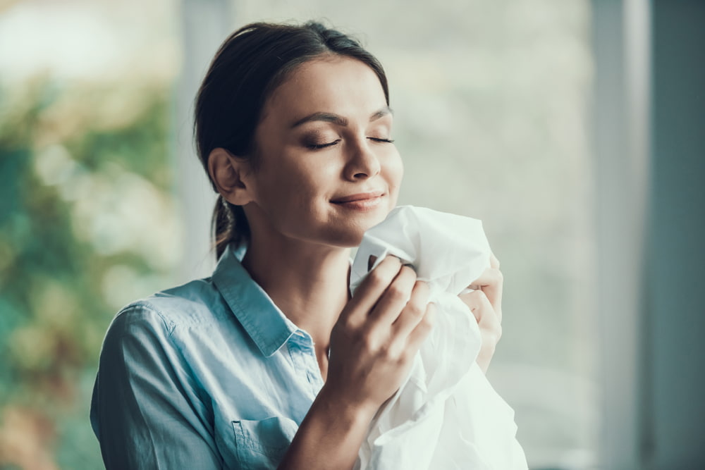 woman smelling her laundry, smiling