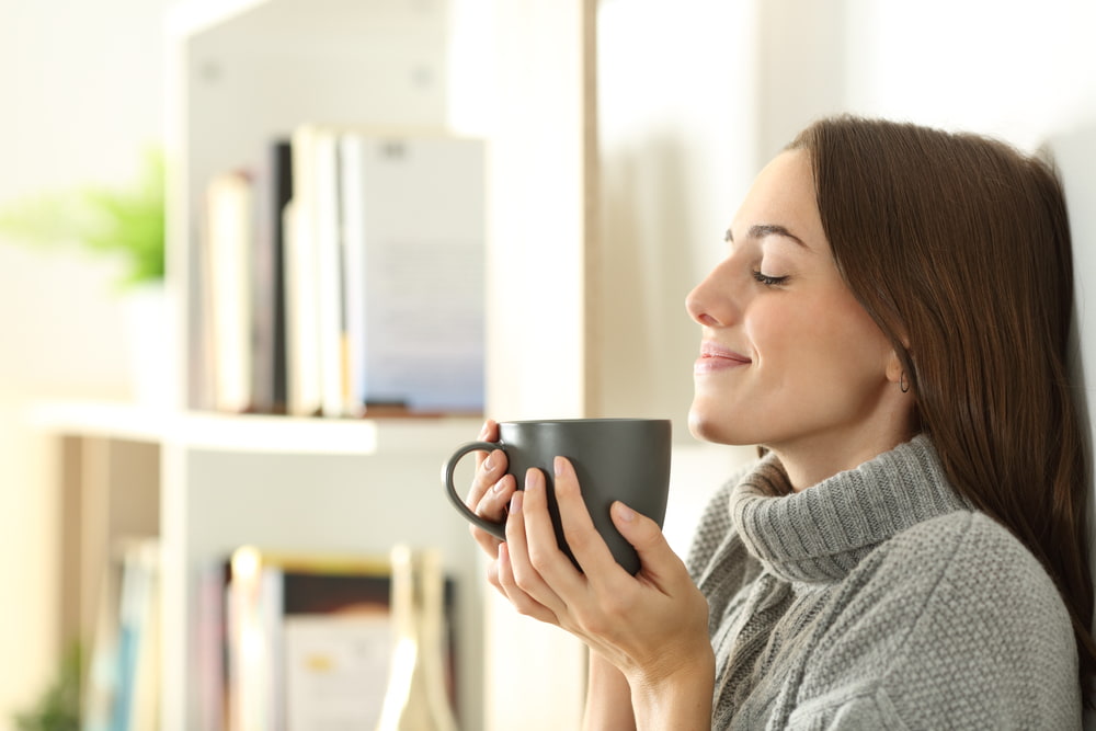 woman smelling coffee and smiling
