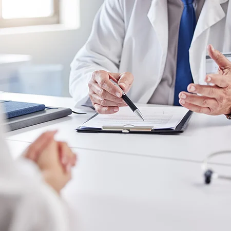 doctor talking to patient and pointing to papers